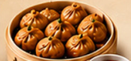 Golden fried chicken momos in a bamboo steamer with red chutney