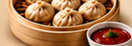 Steamed chicken momos in a bamboo steamer